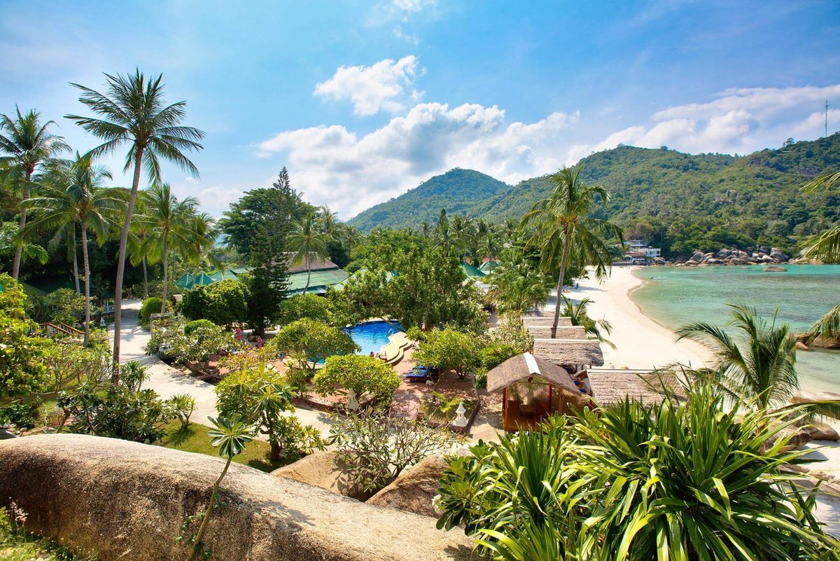 The Yacht Club gardens, pool and thatched salas above the beach and the bay
